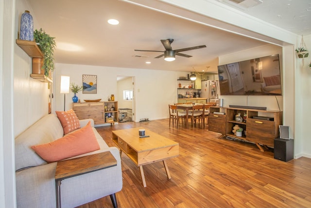 living area with recessed lighting, visible vents, wood finished floors, and a ceiling fan
