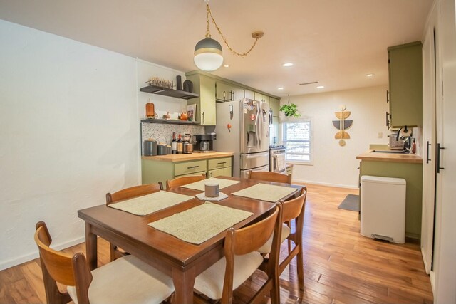 dining room featuring light wood-style flooring, recessed lighting, and baseboards