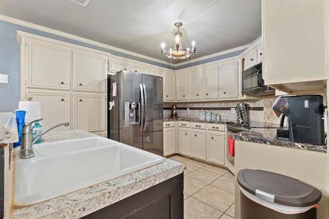 kitchen with appliances with stainless steel finishes, tasteful backsplash, sink, light tile patterned floors, and a notable chandelier