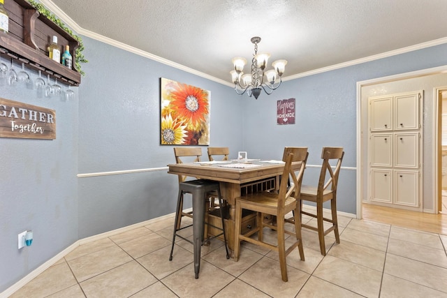 tiled dining room with ornamental molding, a textured ceiling, and a notable chandelier