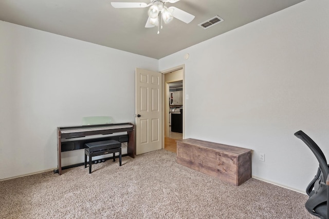 carpeted office space featuring ceiling fan