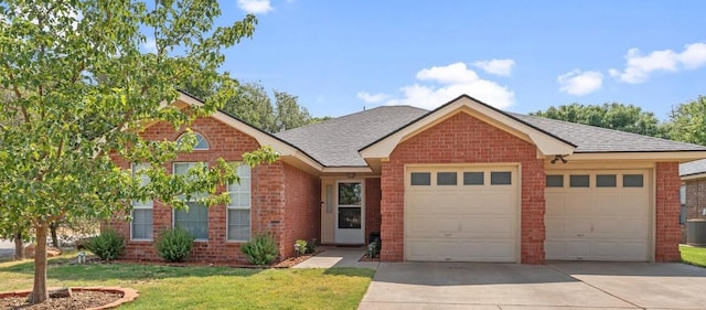 view of front facade with central AC, a garage, and a front yard