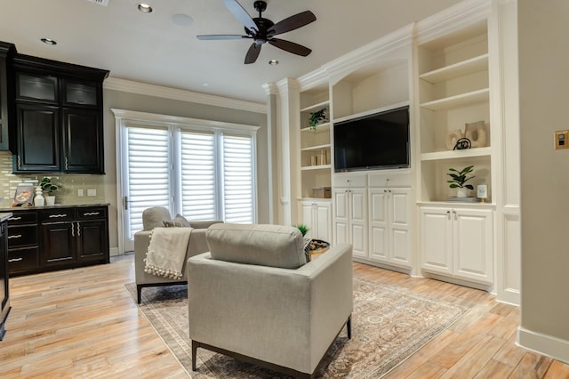 living room with ornamental molding, light hardwood / wood-style floors, and ceiling fan