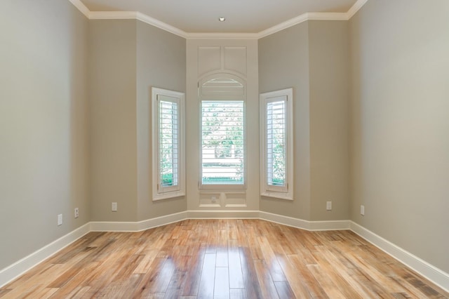 unfurnished room with ornamental molding and light wood-type flooring