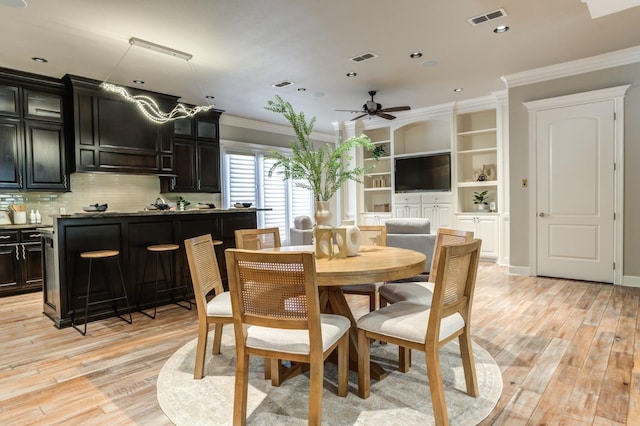 dining area with ornamental molding, ceiling fan, and light hardwood / wood-style flooring