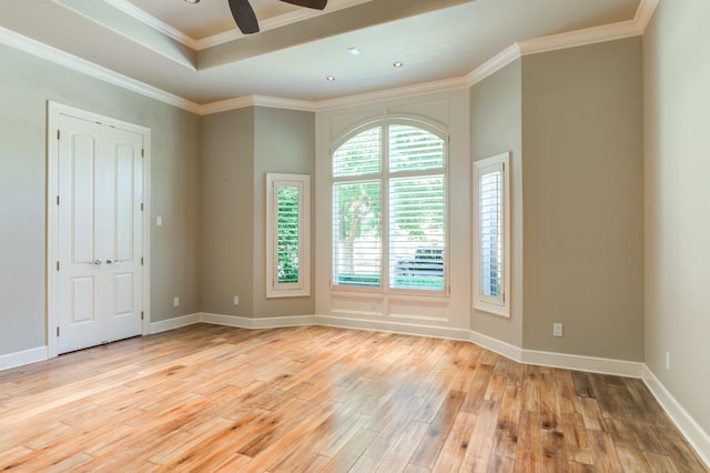 spare room featuring a raised ceiling, ornamental molding, ceiling fan, and light hardwood / wood-style floors