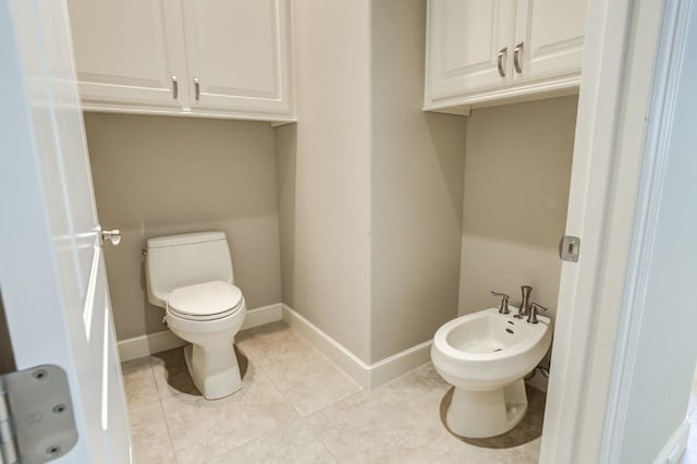 bathroom with a bidet, tile patterned floors, and toilet