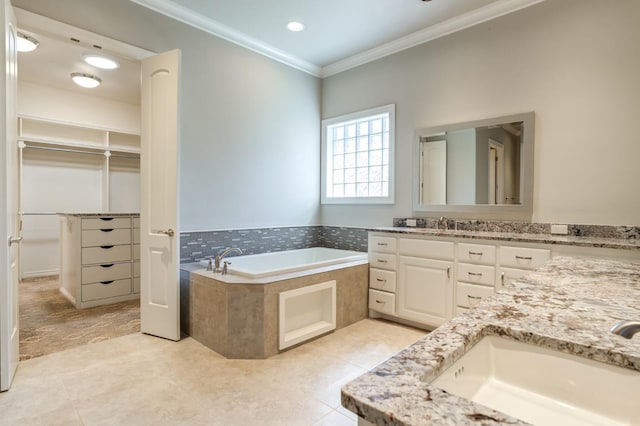 bathroom with tile patterned flooring, vanity, tiled bath, and crown molding