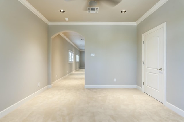 spare room featuring ornamental molding, light colored carpet, and ceiling fan