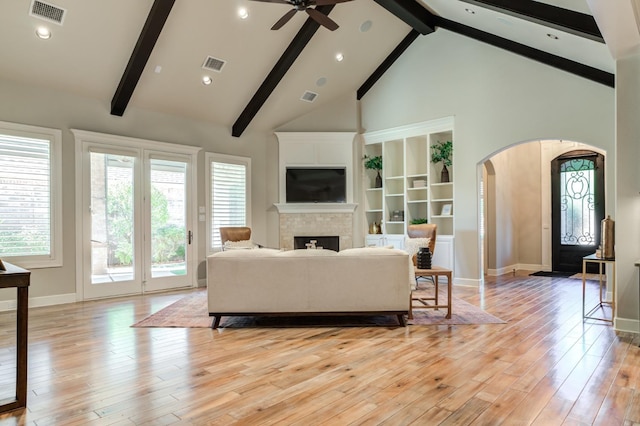 living room with beamed ceiling, ceiling fan, high vaulted ceiling, and light hardwood / wood-style flooring