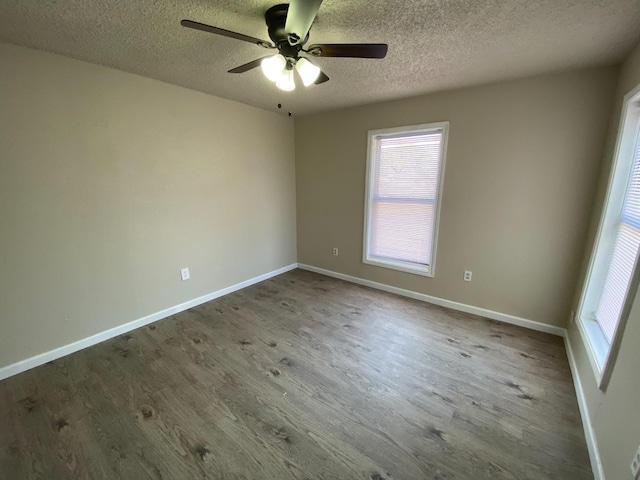 empty room with ceiling fan, hardwood / wood-style floors, and a textured ceiling