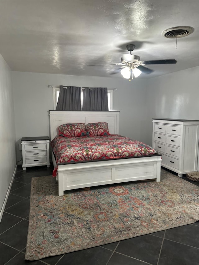 bedroom with ceiling fan and dark tile patterned flooring