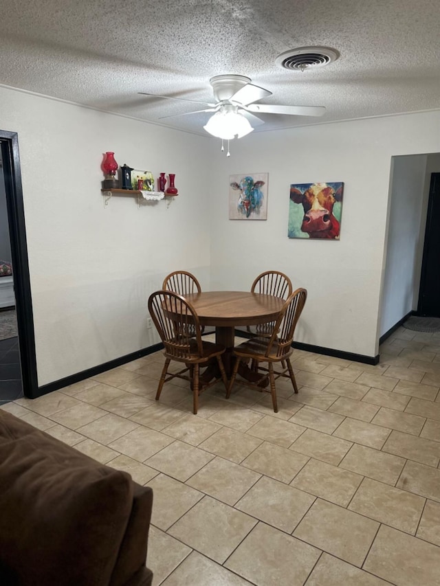 tiled dining space featuring ceiling fan and a textured ceiling