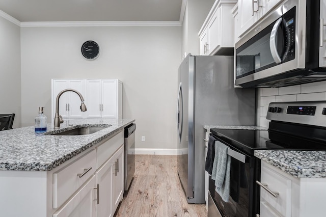 kitchen featuring a sink, white cabinetry, crown molding, light wood-style floors, and appliances with stainless steel finishes