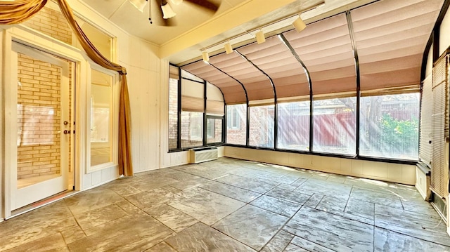 unfurnished sunroom featuring ceiling fan, lofted ceiling, and an AC wall unit