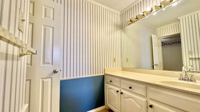 bathroom with ornamental molding, vanity, and a textured ceiling