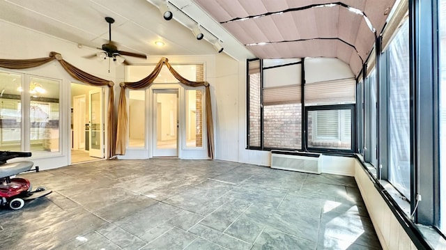 interior space featuring ceiling fan, a wall mounted AC, vaulted ceiling, and a wealth of natural light