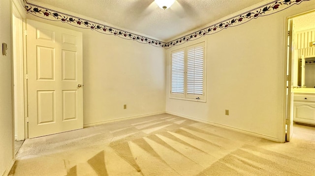 unfurnished bedroom featuring ceiling fan, light carpet, and a textured ceiling