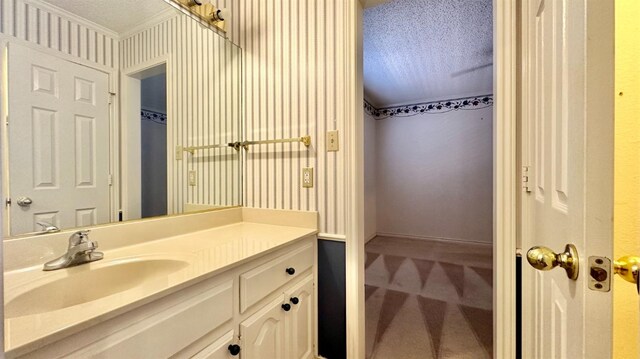 bathroom featuring vanity, crown molding, and a textured ceiling