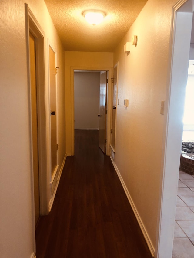3423 94th St, Lubbock, TX 79423 - hallway featuring a textured ceiling, wood finished floors, and baseboards