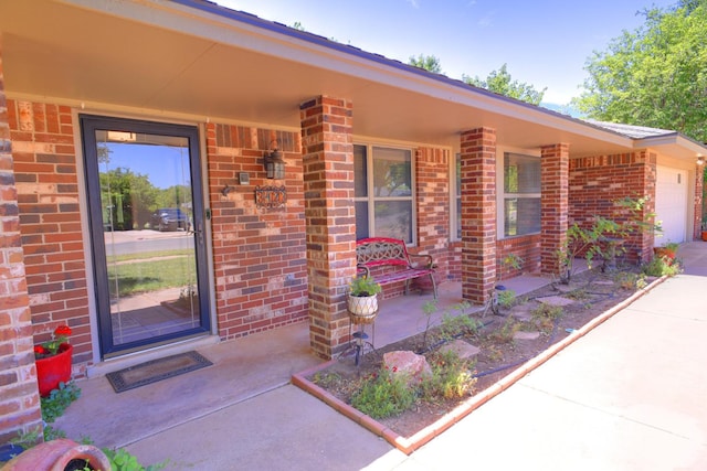 3423 94th St, Lubbock, TX 79423 - property entrance with brick siding, a garage, and covered porch