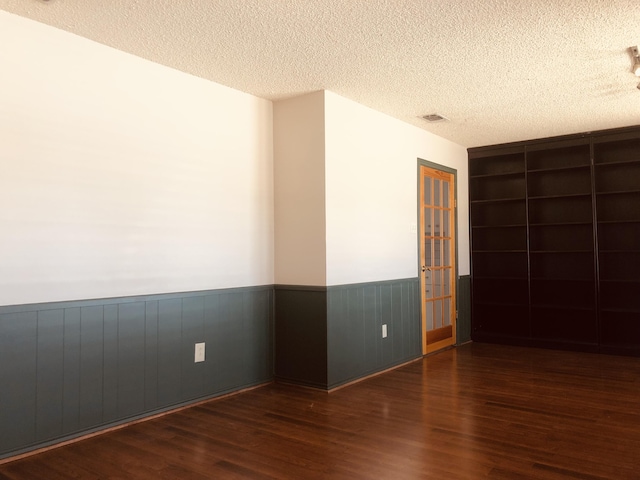 3423 94th St, Lubbock, TX 79423 - spare room featuring a wainscoted wall, wood finished floors, and a textured ceiling