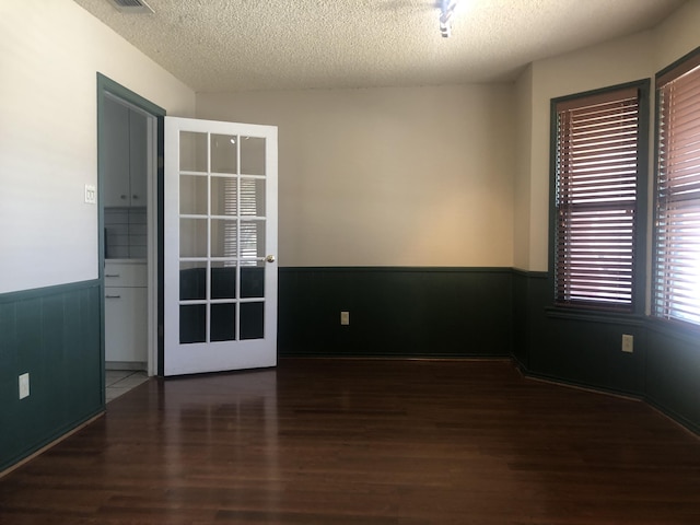 3423 94th St, Lubbock, TX 79423 - unfurnished room featuring wood finished floors, a wainscoted wall, and a textured ceiling