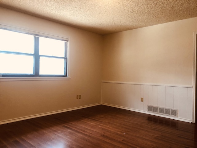 3423 94th St, Lubbock, TX 79423 - unfurnished room with wood finished floors, a textured ceiling, wainscoting, and baseboards