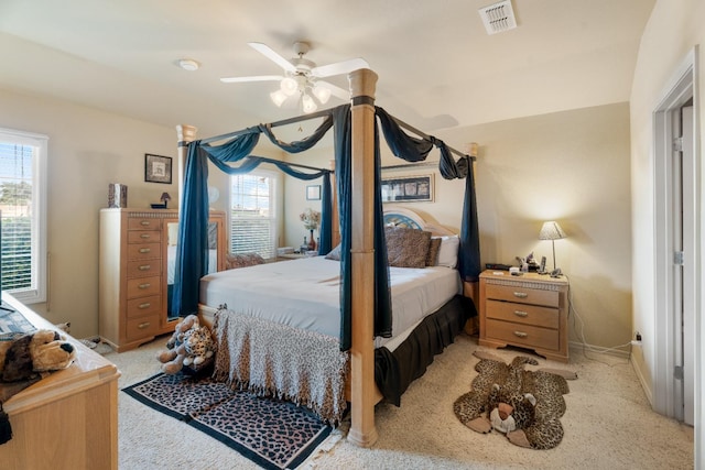 carpeted bedroom featuring multiple windows and ceiling fan