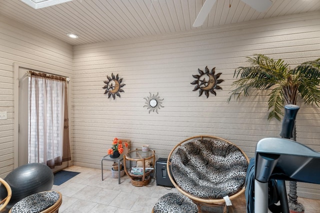 sitting room with wood ceiling, a skylight, and light tile patterned floors