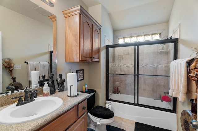 full bathroom featuring toilet, shower / bath combination with glass door, vaulted ceiling, vanity, and tile patterned flooring