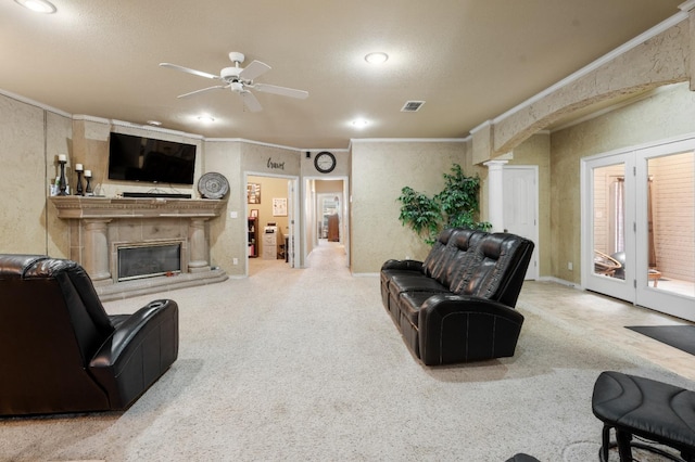 carpeted living room featuring crown molding, decorative columns, french doors, and ceiling fan