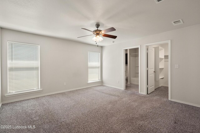 10303 Valencia Ave, Lubbock, TX 79424 - unfurnished bedroom featuring carpet floors, baseboards, a walk in closet, a ceiling fan, and ensuite bathroom