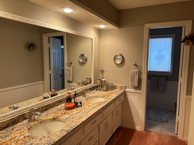3004 80th St, Lubbock, TX 79423 - bathroom featuring double vanity and wainscoting