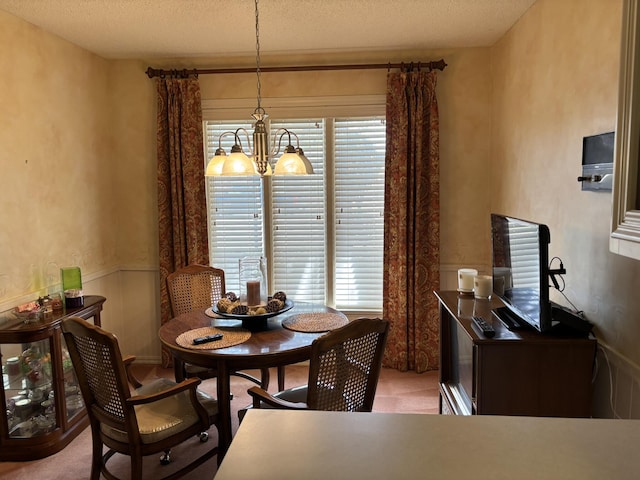 3004 80th St, Lubbock, TX 79423 - dining space with a chandelier, a wainscoted wall, and a textured ceiling
