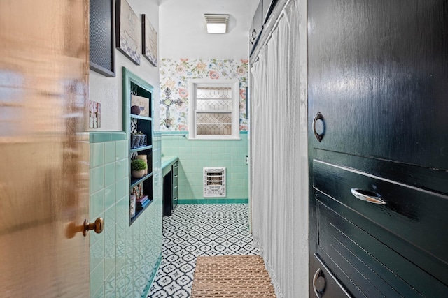 bathroom featuring heating unit and tile walls