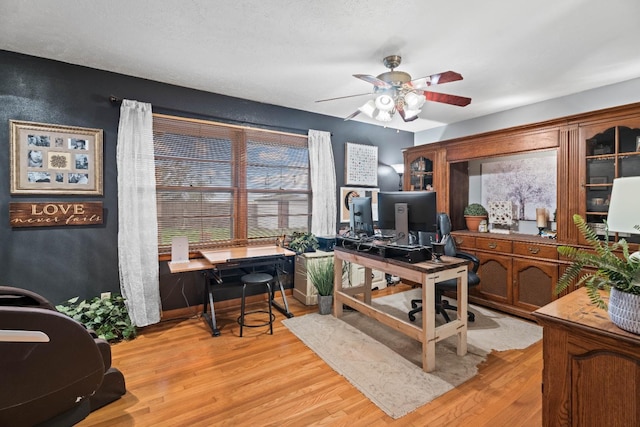 home office with plenty of natural light, light hardwood / wood-style floors, and ceiling fan