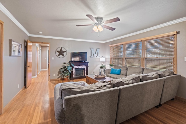 living room with hardwood / wood-style flooring, ceiling fan, and ornamental molding