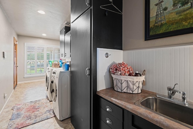 washroom with cabinets, light tile patterned flooring, separate washer and dryer, and sink