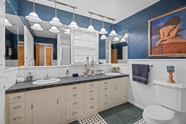 bathroom featuring vanity, a shower with shower door, and toilet