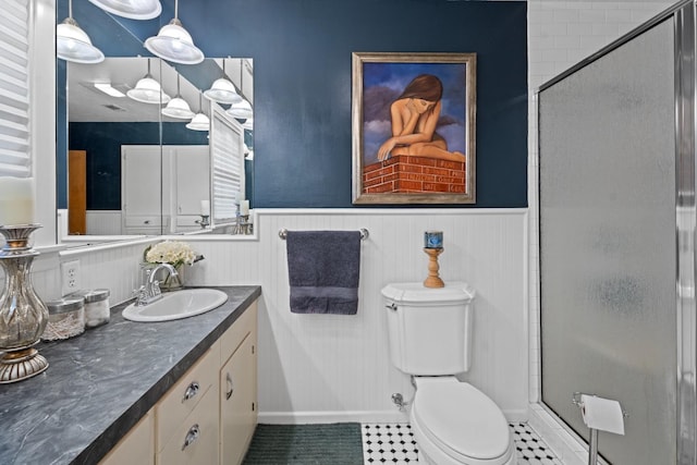 bathroom featuring a shower with door, vanity, tile patterned floors, and toilet