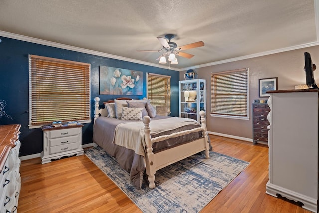 bedroom featuring ceiling fan, ornamental molding, light hardwood / wood-style flooring, and a textured ceiling