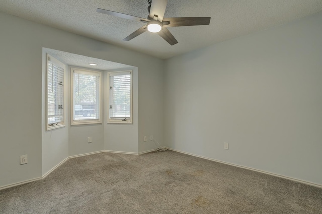 empty room with light carpet, ceiling fan, and a textured ceiling