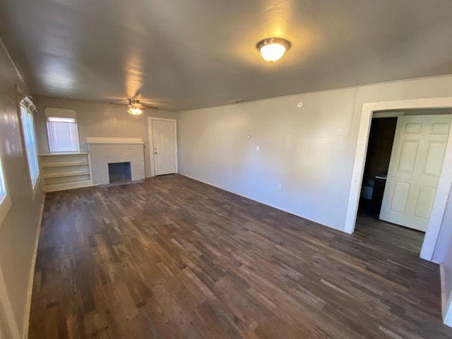 unfurnished living room with dark hardwood / wood-style floors, ceiling fan, and a fireplace