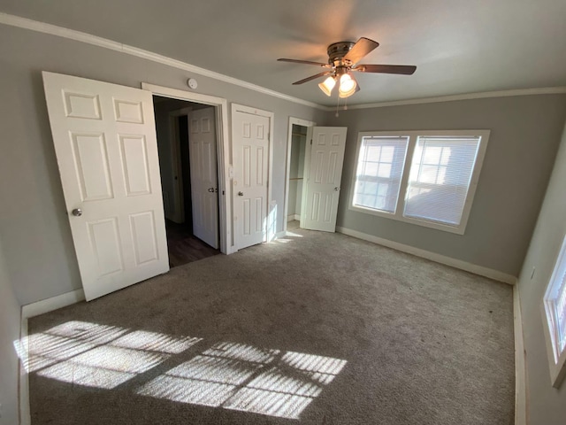 unfurnished bedroom featuring ornamental molding, a closet, ceiling fan, and dark colored carpet