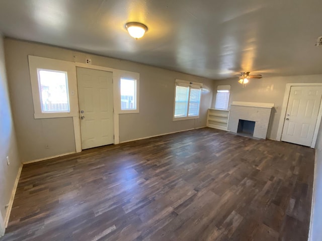 unfurnished living room with dark hardwood / wood-style flooring, a fireplace, and ceiling fan