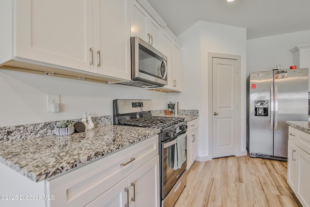 7406 9th St, Lubbock, TX 79416 - kitchen with appliances with stainless steel finishes, light wood finished floors, white cabinets, and light stone countertops