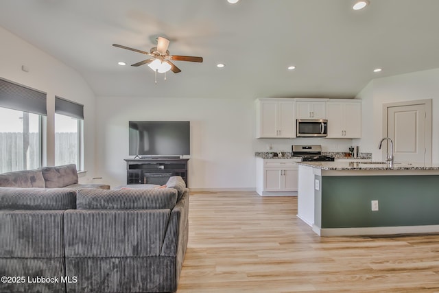 7406 9th St, Lubbock, TX 79416 - kitchen featuring appliances with stainless steel finishes, open floor plan, a sink, light stone countertops, and recessed lighting