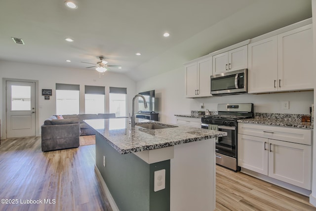 7406 9th St, Lubbock, TX 79416 - kitchen featuring stainless steel appliances, a sink, stone counters, ceiling fan, and light wood-type flooring