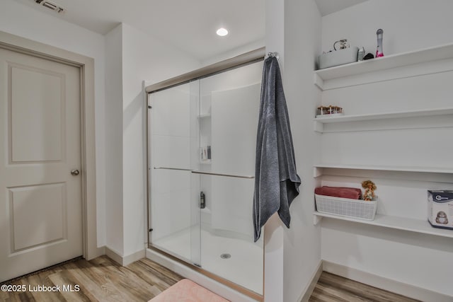 7406 9th St, Lubbock, TX 79416 - full bathroom with wood finished floors, a shower stall, and baseboards